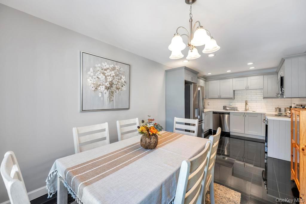 114 Birchwood Road Coram, NY 11727 - Photo 10 of 24 a dining room with wooden floor and a chandelier