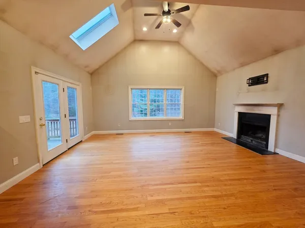 a view of an empty room with a fireplace and a window