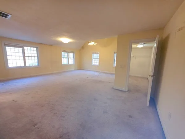 an empty room with a fireplace and windows