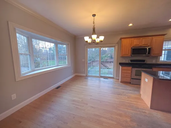 a view of a kitchen with microwave and wooden floor
