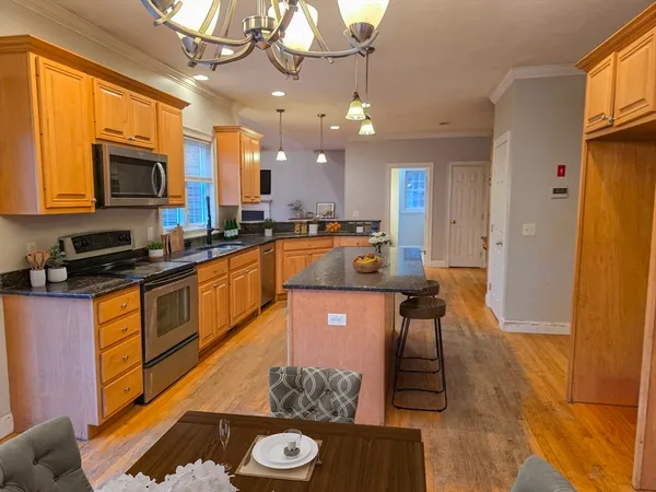 a kitchen with stainless steel appliances granite countertop a sink a stove and a refrigerator