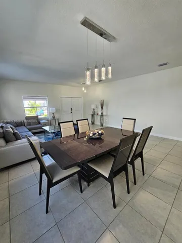 a dining room with a wooden table and chairs