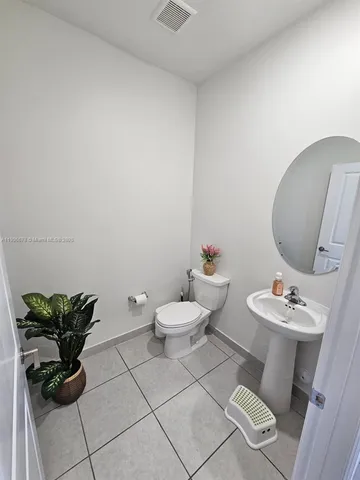 a bathroom with a toilet a sink and a mirror