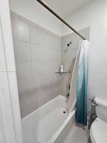 a bathroom with a tub a toilet and a shower