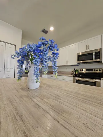 a view of a kitchen with furniture and wooden floor