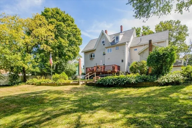 a front view of a house with a yard and potted plants
