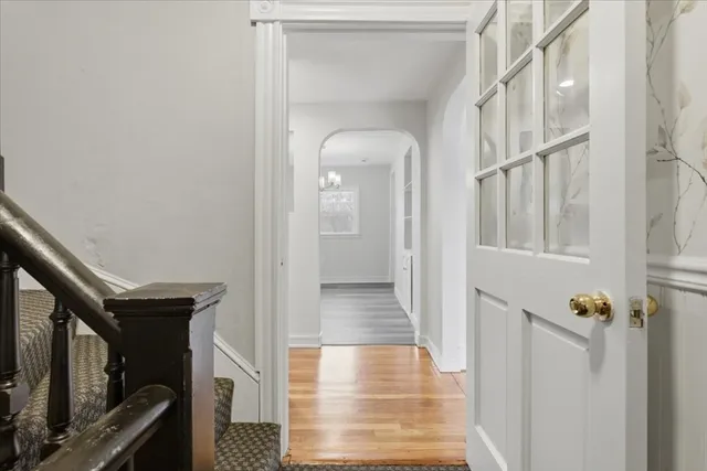 a view of a hallway with wooden floor and staircase