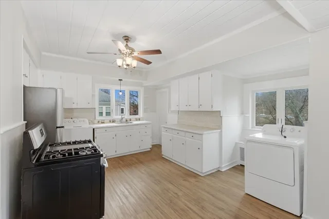 a kitchen with a refrigerator and white cabinets