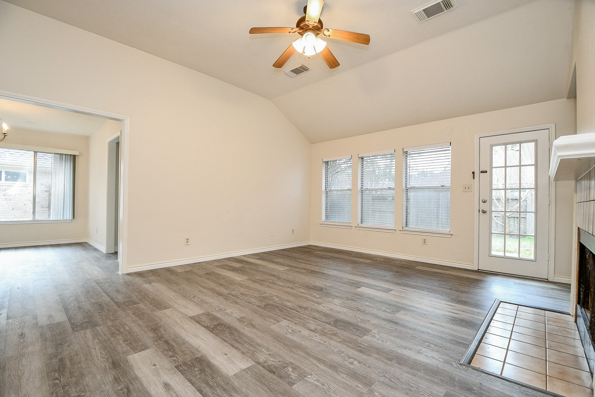 10919 Rustling Winds Drive Houston, TX 77064 - Photo 3 of 20 an empty room with wooden floor chandelier fan and windows