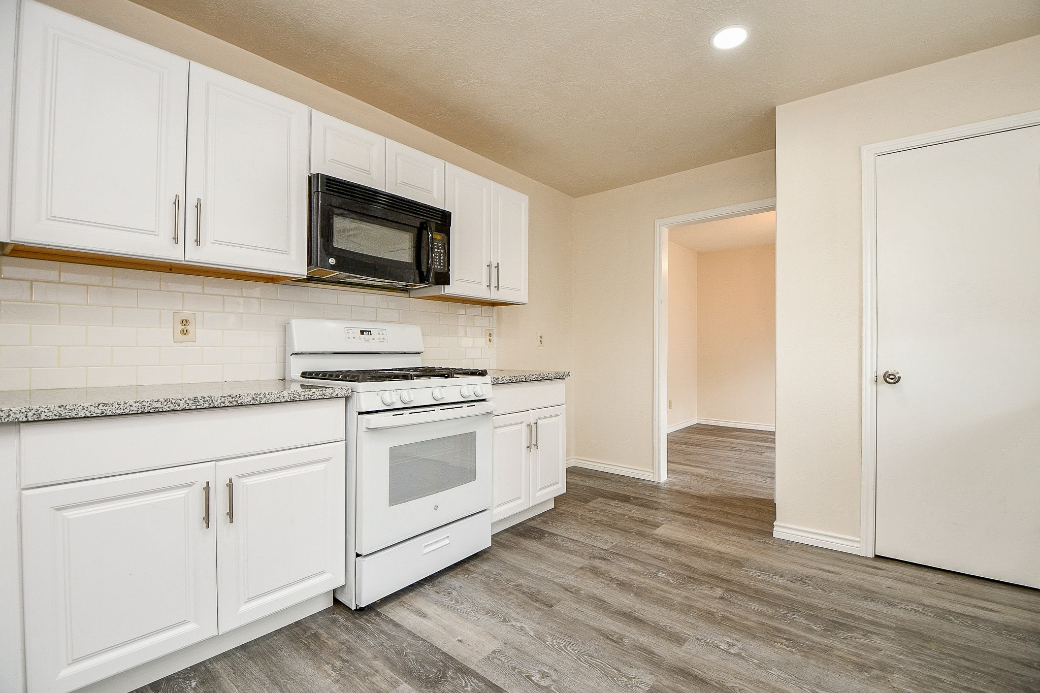 10919 Rustling Winds Drive Houston, TX 77064 - Photo 7 of 20 a kitchen with stainless steel appliances granite countertop a stove a sink and a microwave