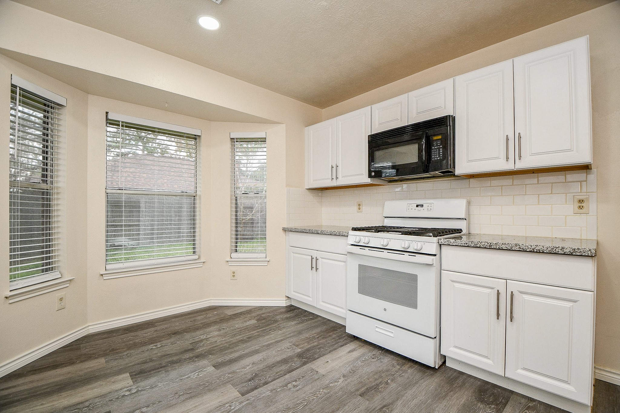 10919 Rustling Winds Drive Houston, TX 77064 - Photo 9 of 20 a kitchen with cabinets stainless steel appliances and wooden floor