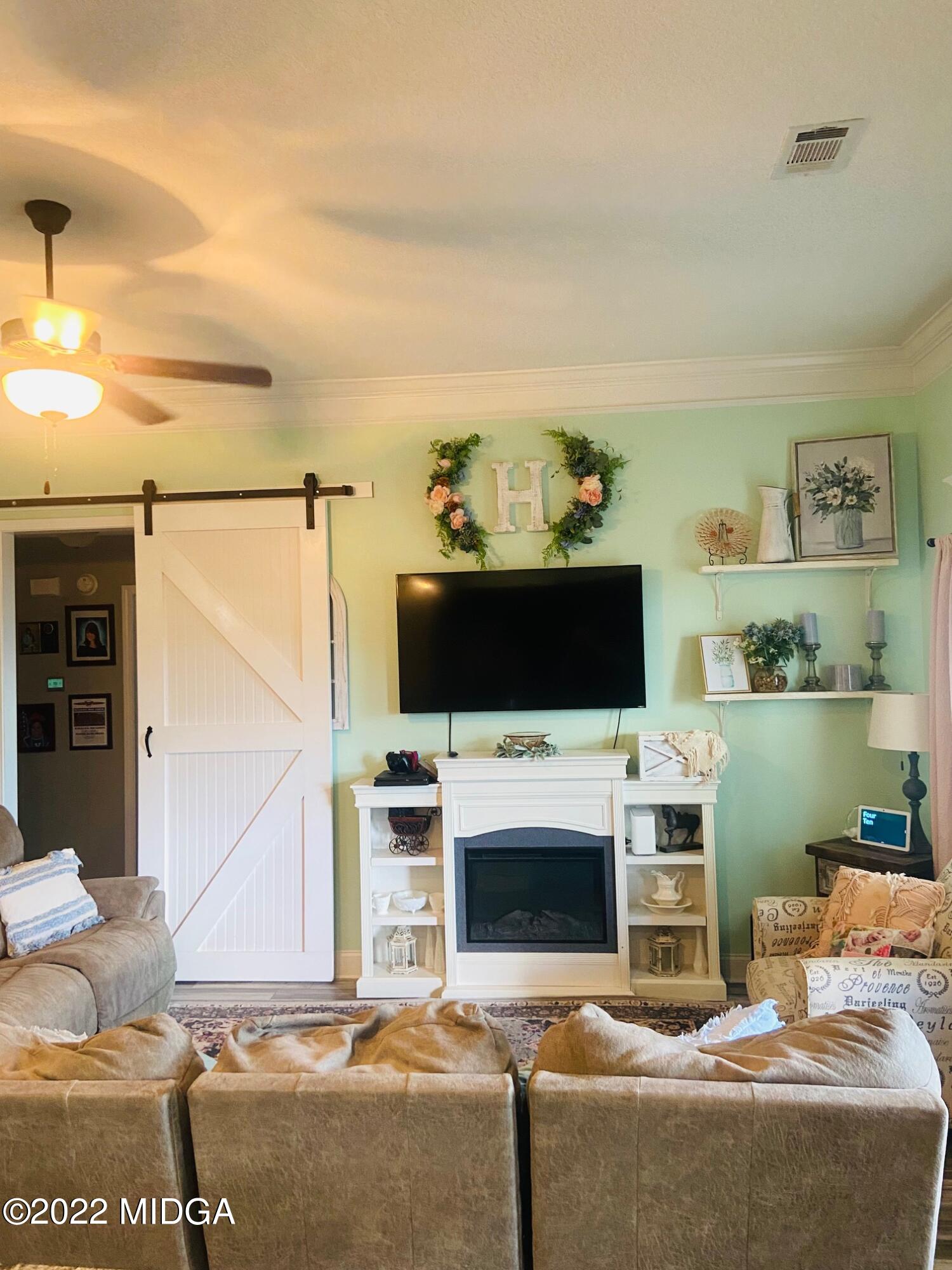 304 Durgin Drive Bonaire, GA 31005 - Photo 2 of 22 a living room with furniture a flat screen tv and a fireplace