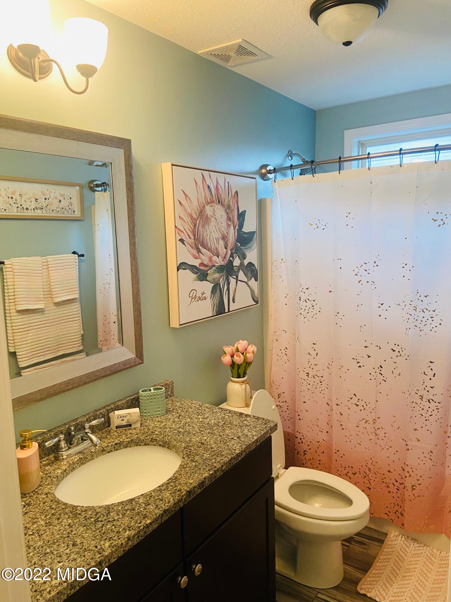 304 Durgin Drive Bonaire, GA 31005 - Photo 9 of 22 a bathroom with a granite countertop sink mirror vanity and toilet