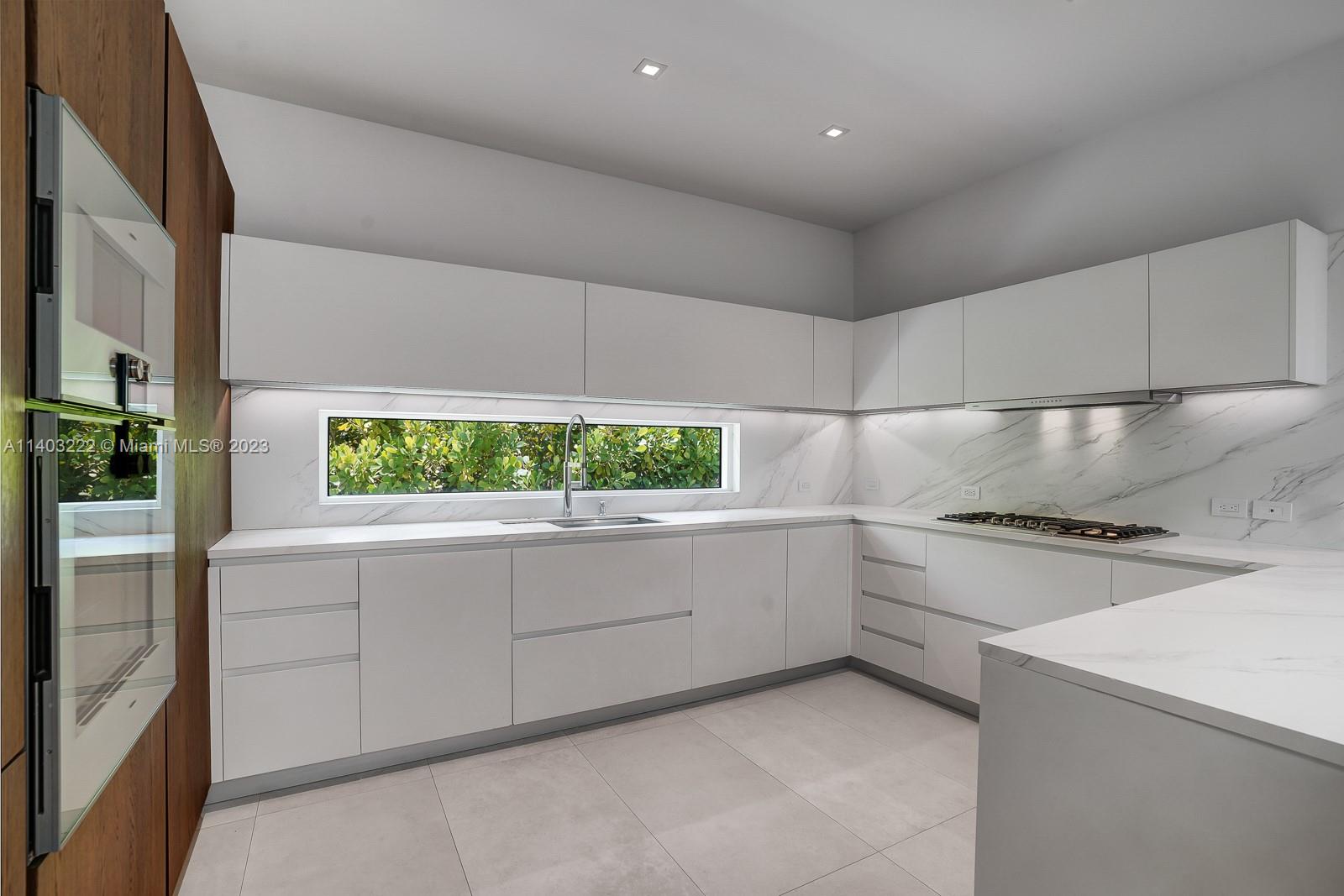 141 Harbor Drive Key Biscayne, FL 33149 - Photo 20 of 56 a kitchen with a stove sink and cabinets