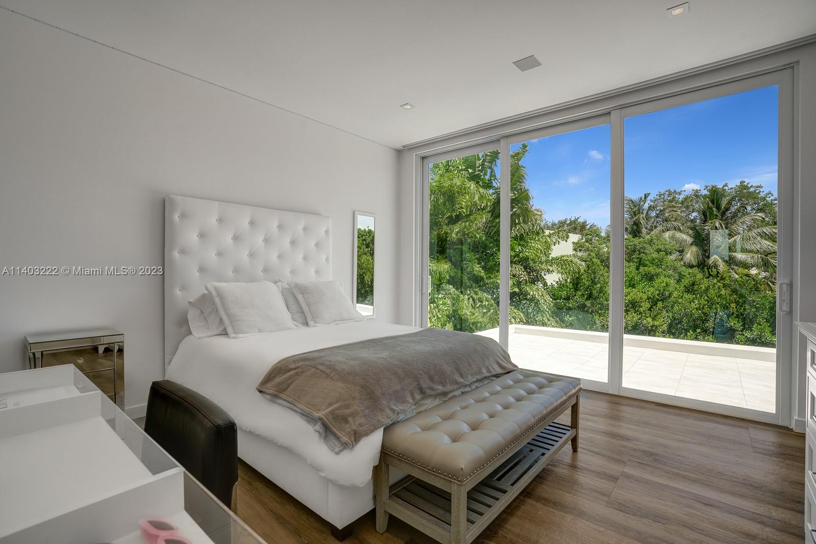 141 Harbor Drive Key Biscayne, FL 33149 - Photo 34 of 56 a bedroom with a bed window and wooden floor