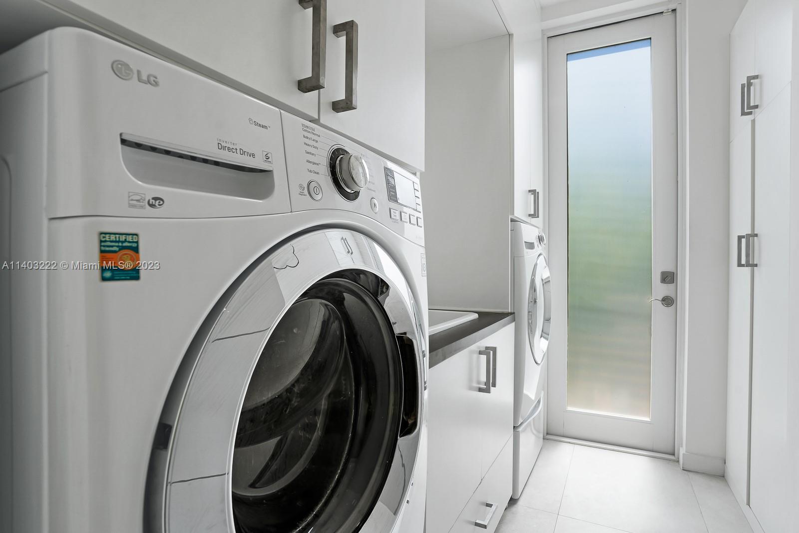 141 Harbor Drive Key Biscayne, FL 33149 - Photo 45 of 56 a view of a storage and utility room with washer and dryer