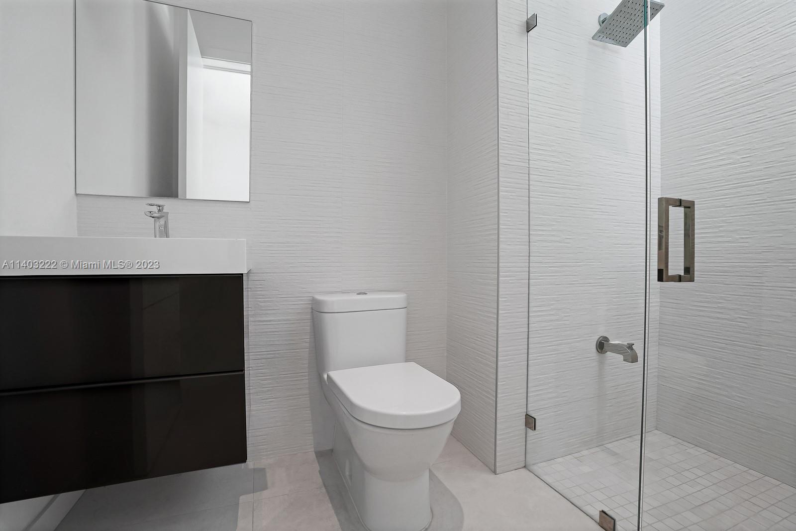 141 Harbor Drive Key Biscayne, FL 33149 - Photo 47 of 56 a bathroom with a toilet a sink and shower