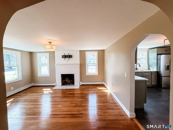 a view of a livingroom with wooden floor and a fireplace