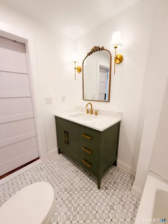a bathroom with a sink a toilet and mirror