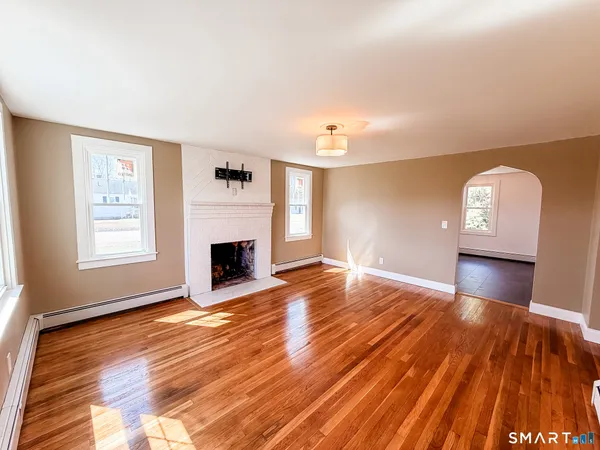 wooden floor fireplace and natural light in room