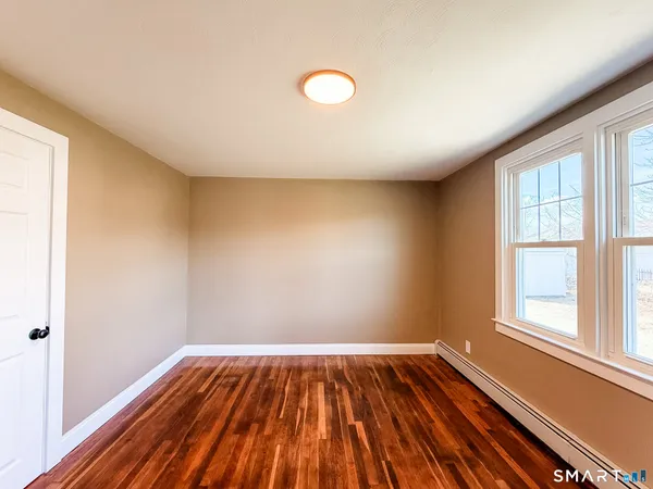 a view of empty room with wooden floor
