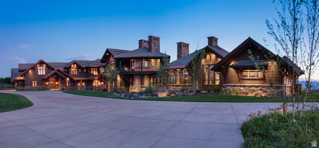 2322 North Westward Ho Road Heber City, UT 84036 - Photo 42 of 54 View of front facade featuring stone siding, a balcony, curved driveway, a chimney, and a front lawn
