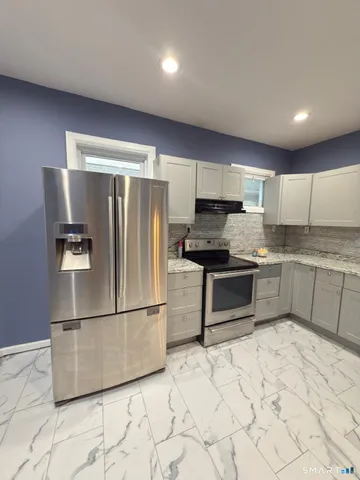 a kitchen with granite countertop a refrigerator and a sink