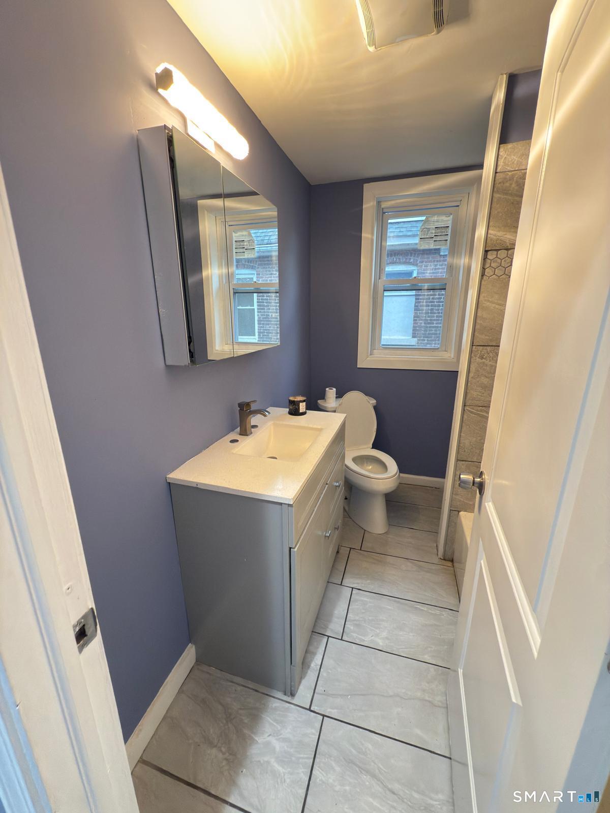 185 Read Street, Unit 2 Bridgeport, CT 06607 - Photo 9 of 10 a bathroom with a sink and mirror with toilet