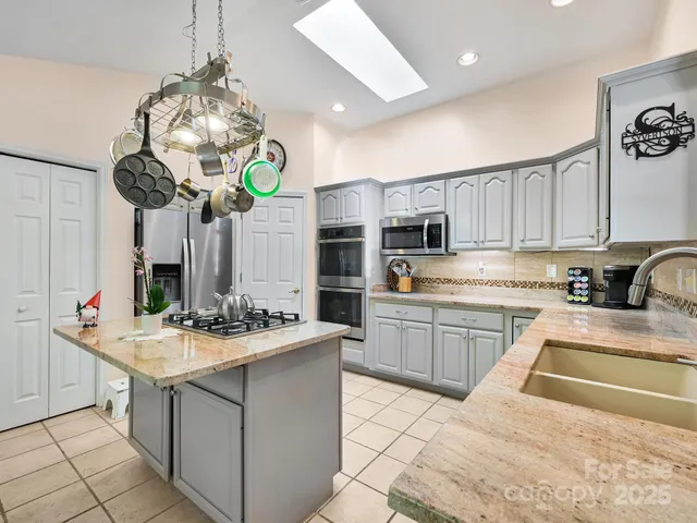 a kitchen with stainless steel appliances granite countertop a stove and a sink