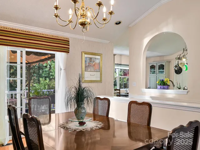a view of a dining room with furniture a chandelier and wooden floor