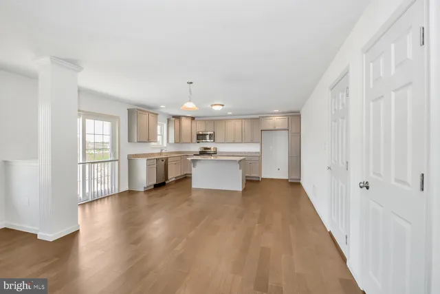 a view of a kitchen with wooden floor and windows