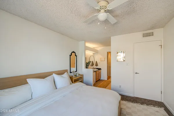 a bedroom with a large bed and ceiling fan