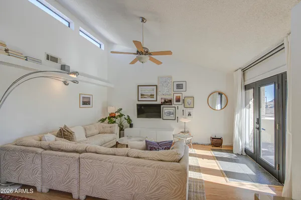 a living room with furniture a clock and a ceiling fan