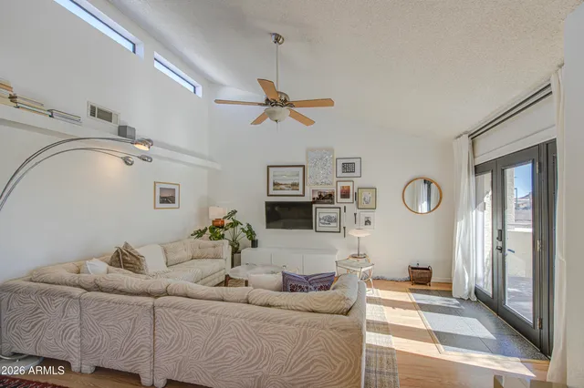 a living room with furniture a clock and a ceiling fan