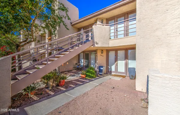 a view of a house with a yard and potted plants