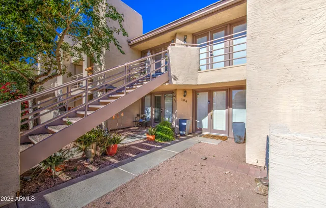 a view of a house with a yard and potted plants