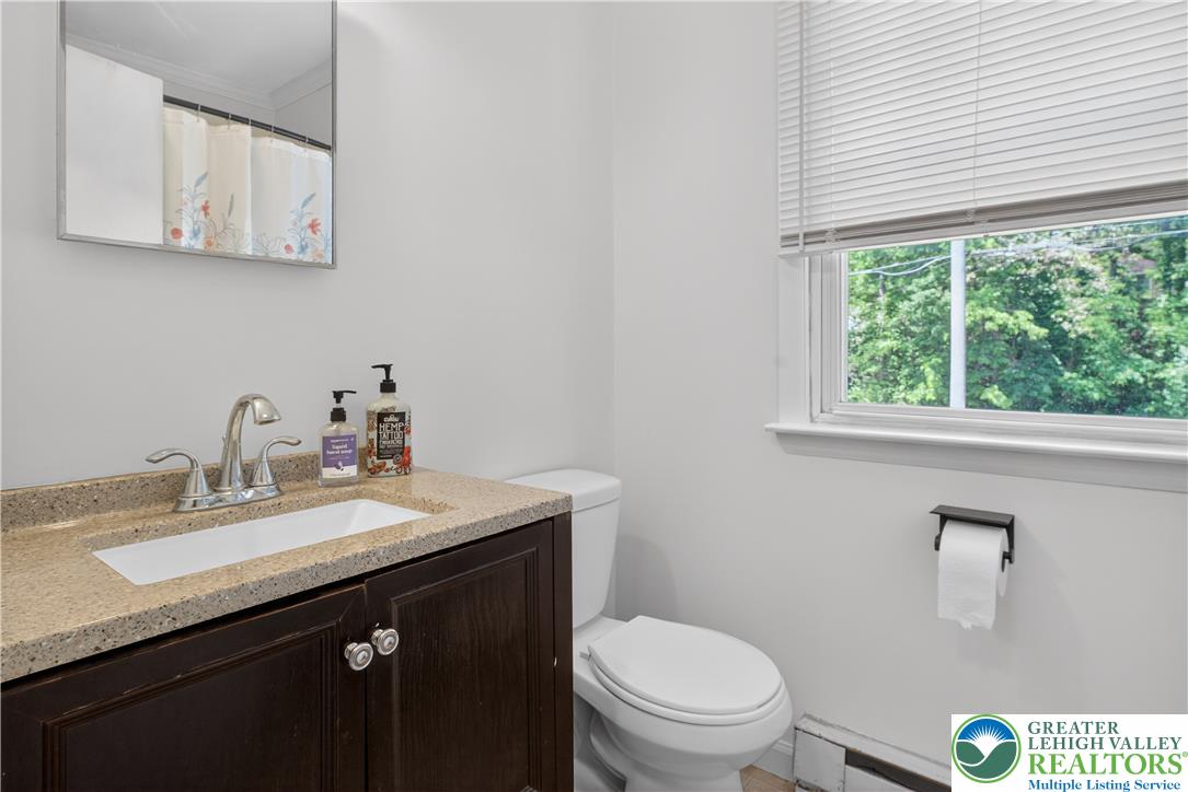 479 South 9th Street Akron, PA 17501 - Photo 11 of 33 A well-lit bathroom features a vanity with granite counters and a practical window providing abundant light.