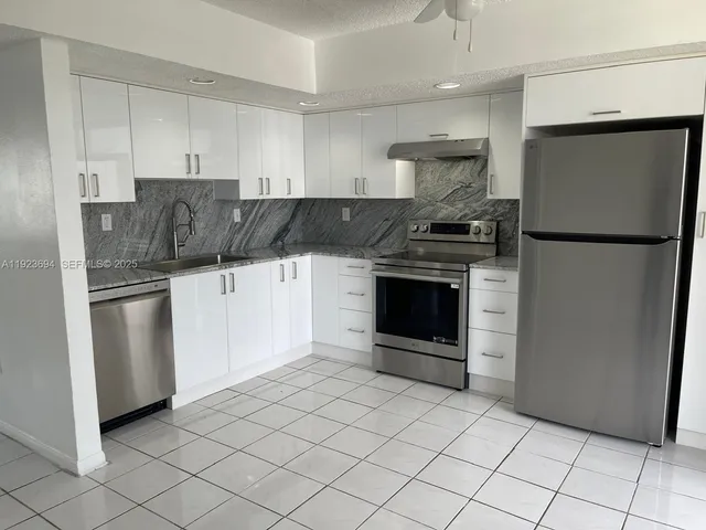 a kitchen with stainless steel appliances granite countertop a refrigerator sink and stove