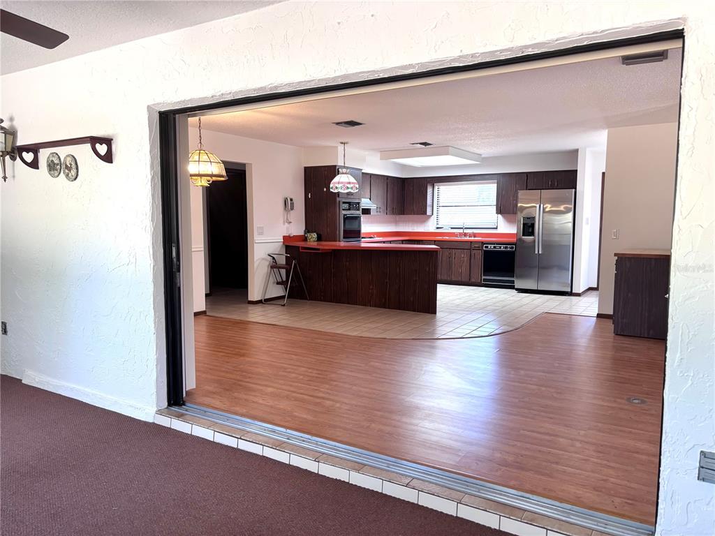 324 Alemander Avenue DeBary, FL 32713 - Photo 29 of 40 a view of living room kitchen with furniture and wooden floor