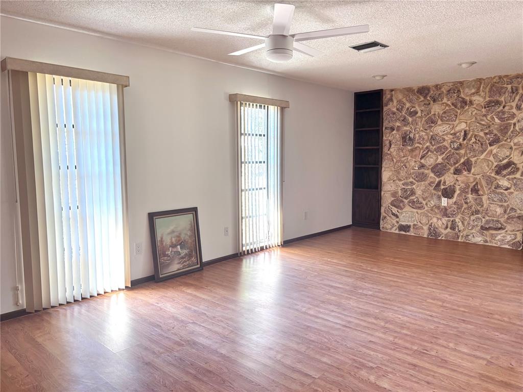 324 Alemander Avenue DeBary, FL 32713 - Photo 3 of 40 an empty room with wooden floor chandelier fan and windows