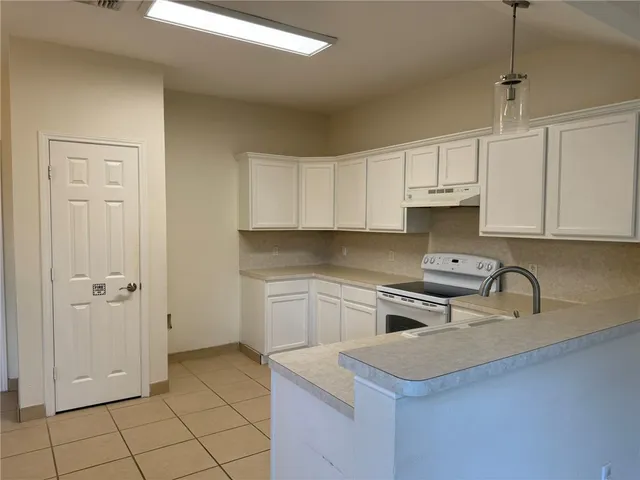 a kitchen with a stove sink and cabinets