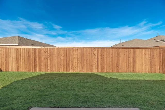 a view of a yard with wooden fence