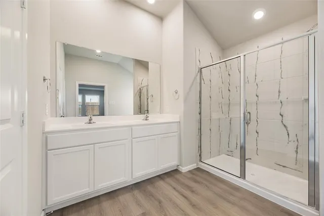 a spacious bathroom with a shower sink and mirror