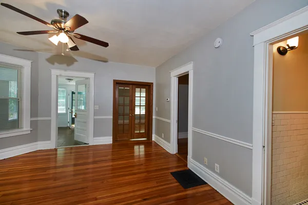 a view of an empty room with wooden floor and a window