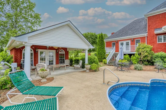 a view of a white house with a big yard and large trees