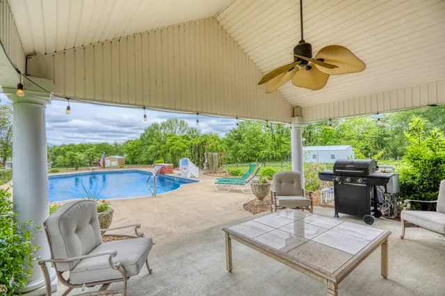 a view of a house with backyard and a tree