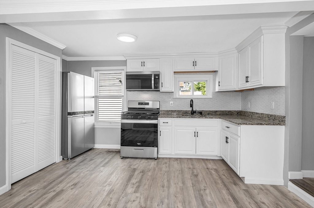 213 Prospect Street Lawrence, MA 01841 - Photo 11 of 33 a kitchen with granite countertop a refrigerator stove and sink