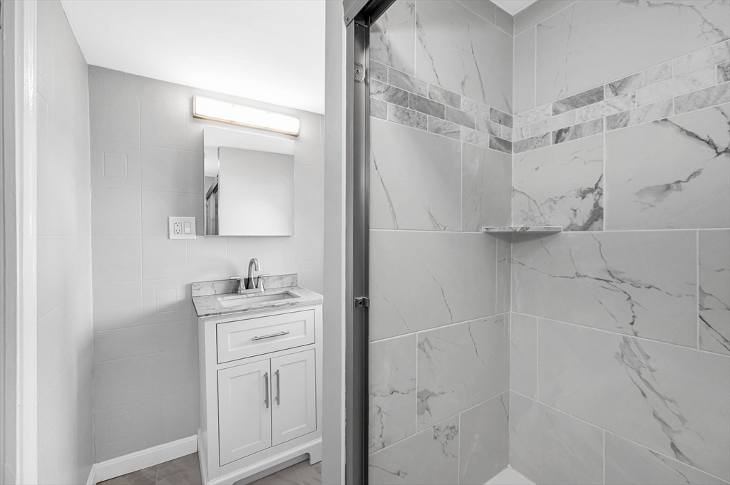 213 Prospect Street Lawrence, MA 01841 - Photo 16 of 33 a bathroom with a granite countertop sink a vanity and shower