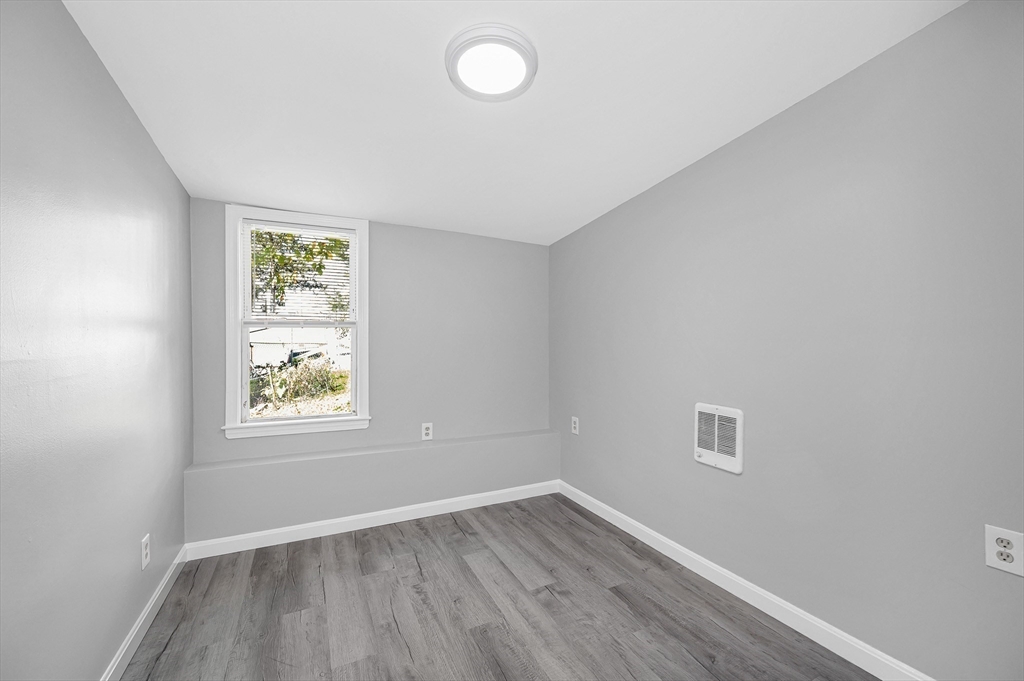213 Prospect Street Lawrence, MA 01841 - Photo 19 of 33 an empty room with wooden floor and windows