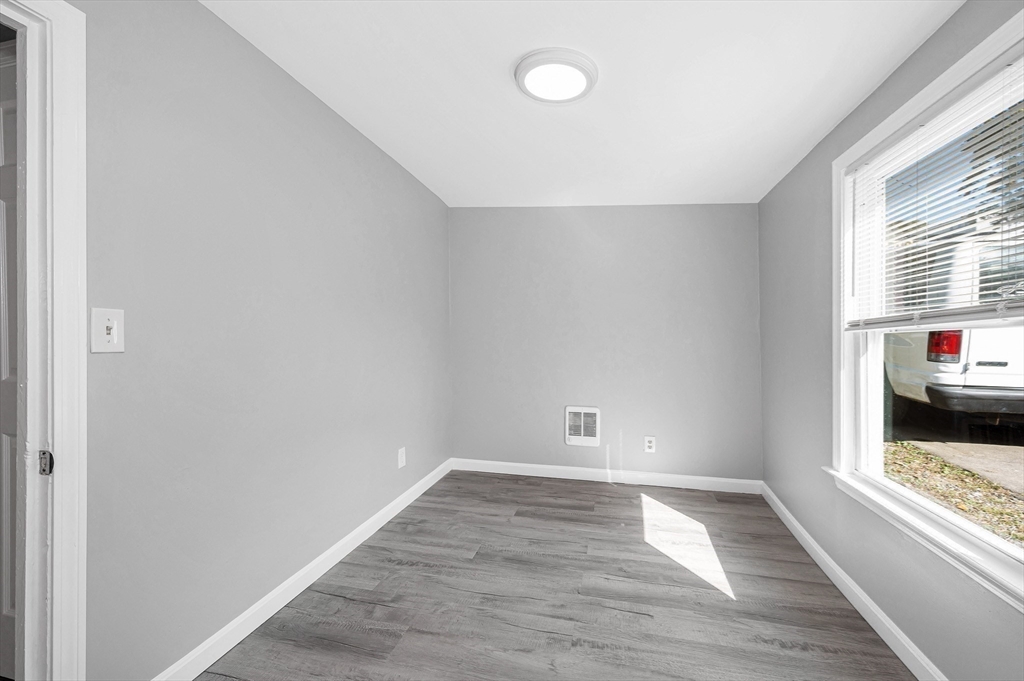 213 Prospect Street Lawrence, MA 01841 - Photo 21 of 33 an empty room with wooden floor and windows